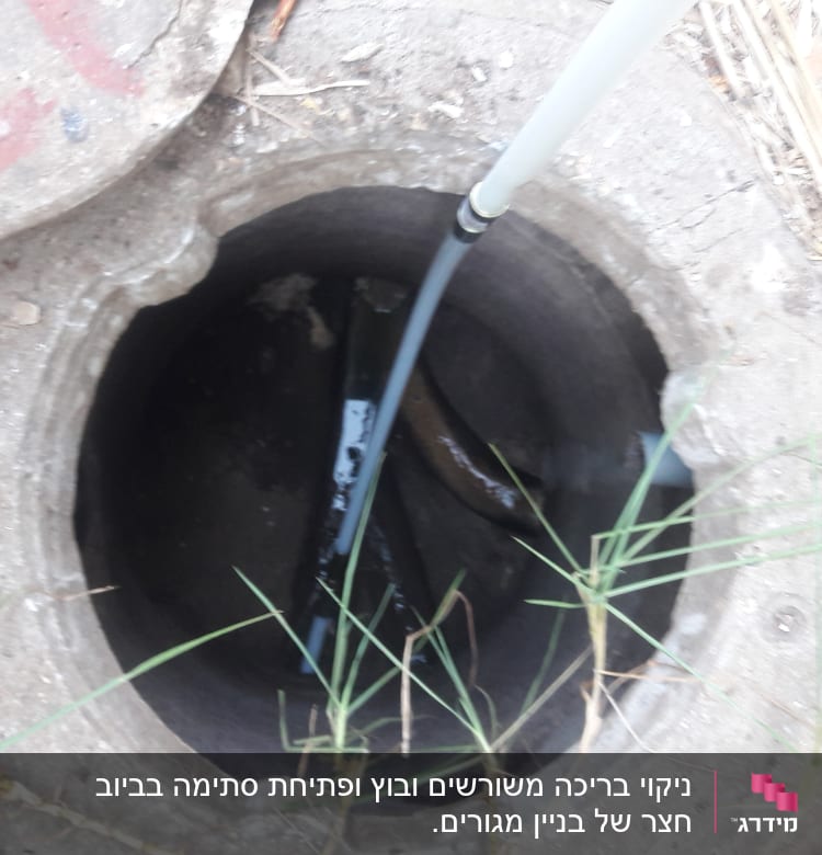 צינור נכנס לפתח ביוב עם מכסה בטון